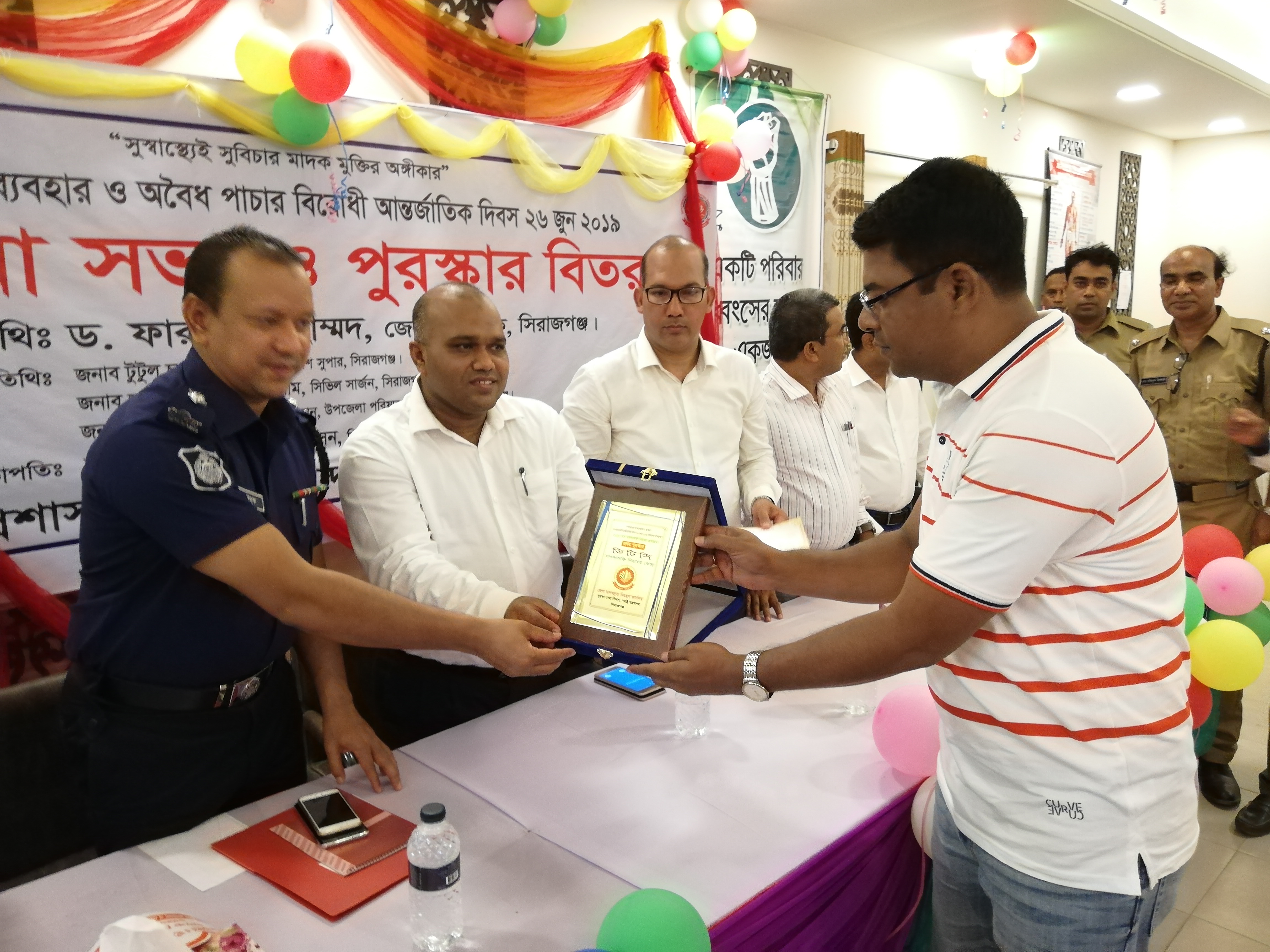 মাদকাসক্তি নিরাময় কার্যক্রম পরিচালনার জন্য জেলা মাদকদ্রব্য নিয়ন্ত্রণ কার্যালয়ের মূল্যায়নে প্রথম স্থান অর্জন করায় ক্রেষ্ট প্রদান করছেন জেলা প্রশাসক ডঃ ফারুক আহমেদ